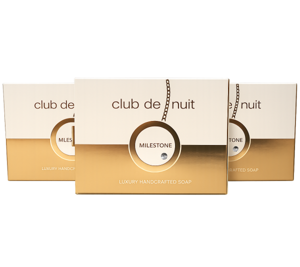 Three boxes of Club de Nuit Milestone luxury handcrafted soap with gold and white packaging are displayed against a white background. Three boxes of Club de Nuit Milestone luxury handcrafted soap with gold and white packaging are displayed against a white background.