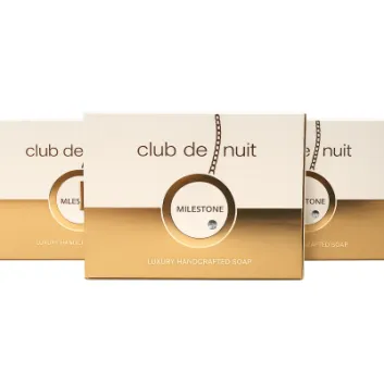 Three boxes of Club de Nuit Milestone luxury handcrafted soap with gold and white packaging are displayed against a white background.