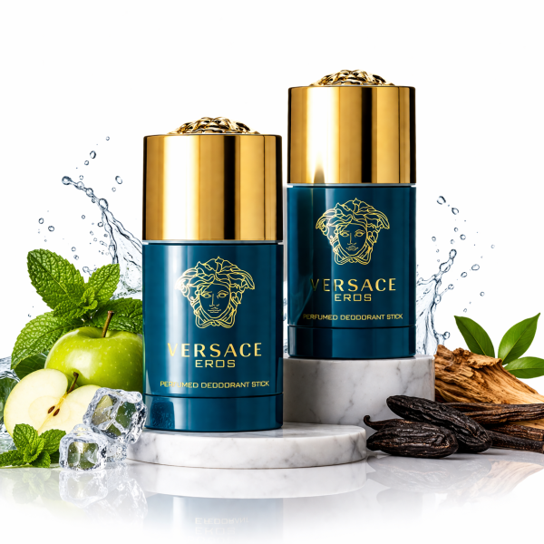 Two 75ml Versace Eros Deodorant Sticks for Men with gold lids are shown on a marble platform, surrounded by mint leaves, green apple, vanilla beans, ice cubes, and splashing water.