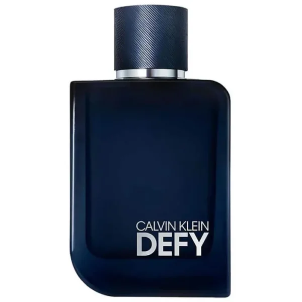 A dark blue rectangular 100ml bottle of Calvin Klein Defy Parfum Spray with a round textured cap and silver lettering on the front. A dark blue rectangular 100ml bottle of Calvin Klein Defy Parfum Spray with a round textured cap and silver lettering on the front.