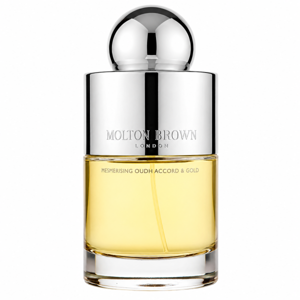 A clear glass bottle with a shiny silver cap holds yellow liquid and is labeled "Molton Brown Mesmerising Oudh Accord & Gold EDT Spray, 100ml. A clear glass bottle with a shiny silver cap holds yellow liquid and is labeled "Molton Brown Mesmerising Oudh Accord & Gold EDT Spray, 100ml.