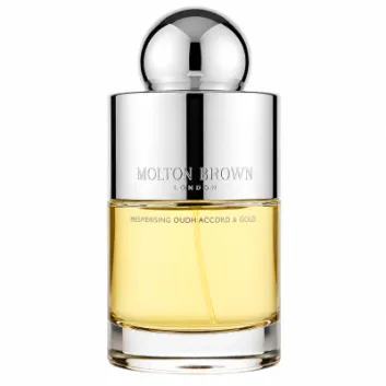 A clear glass bottle with a shiny silver cap holds yellow liquid and is labeled "Molton Brown Mesmerising Oudh Accord & Gold EDT Spray, 100ml.