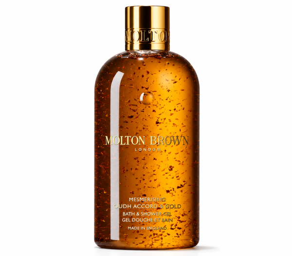 The Molton Brown Mesmerising Oudh Accord & Gold Bath & Shower Gel, 300ml, comes in a clear bottle with visible gold flakes, a gold cap, and gold text on the label.