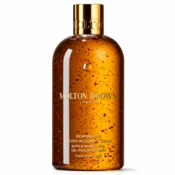 The Molton Brown Mesmerising Oudh Accord & Gold Bath & Shower Gel, 300ml, comes in a clear bottle with visible gold flakes, a gold cap, and gold text on the label.
