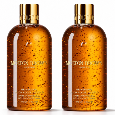 Two bottles of Molton Brown Mesmerising Oudh Accord & Gold Bath & Shower Gel, 300ml each, are shown side by side against a white background. Each features a gold cap and contains suspended gold flakes.
