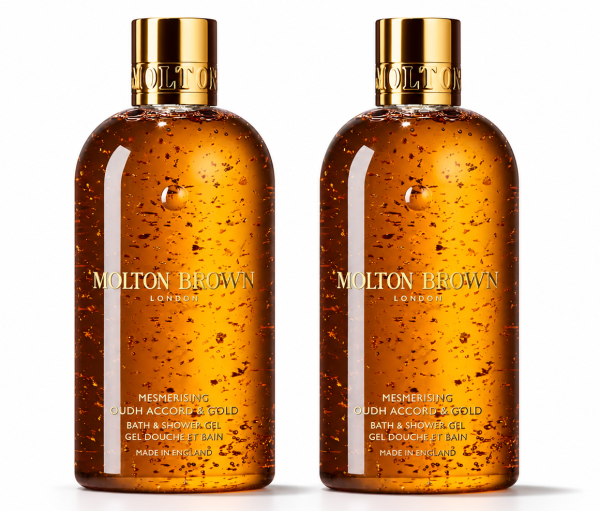 Two bottles of Molton Brown Mesmerising Oudh Accord & Gold Bath & Shower Gel, 300ml each, are shown side by side against a white background. Each features a gold cap and contains suspended gold flakes.