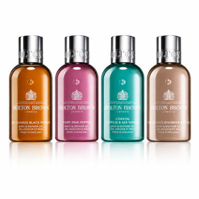 The Molton Brown Woody & Floral Body Care Shower Gel Collection features four 100ml bottles, each in a different color and scent, arranged side by side against a white background.