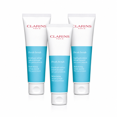 Three Clarins Paris Fresh Scrub tubes are displayed upright, featuring white and blue packaging with red and blue text on a white background.
