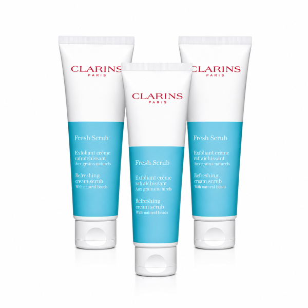 Three Clarins Paris Fresh Scrub tubes are displayed upright, featuring white and blue packaging with red and blue text on a white background.