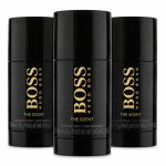 Three black Hugo Boss "The Scent" deodorant sticks are displayed upright, with the center stick slightly in front of the other two.