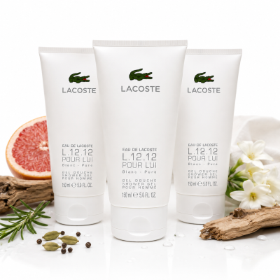 Three tubes of Lacoste L.12.12 Blanc Shower Gel Body Wash, 150ml each, stand upright on a white surface, surrounded by grapefruit, white flowers, rosemary, peppercorns, and driftwood.