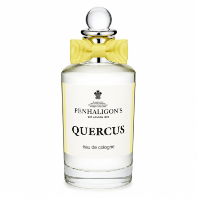 A clear glass bottle of Penhaligon's Quercus eau de cologne with a round stopper and a yellow bow tie, photographed against a white background.