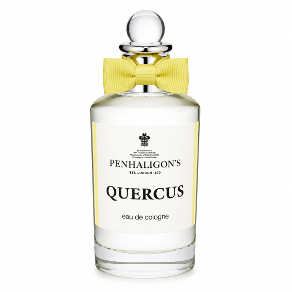 A clear glass bottle of Penhaligon's Quercus eau de cologne with a round stopper and a yellow bow tie, photographed against a white background. A clear glass bottle of Penhaligon's Quercus eau de cologne with a round stopper and a yellow bow tie, photographed against a white background.