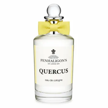 A clear glass bottle of Penhaligon's Quercus eau de cologne with a round stopper and a yellow bow tie, photographed against a white background.