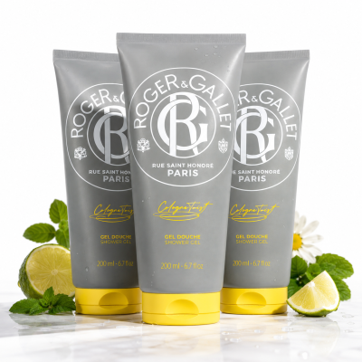 Three upright tubes of 3x Roger & Gallet Cologne Twist Shower Gel, Unisex, 200ml are displayed on a white surface with lemon slices, mint leaves, and chamomile flowers around them.
