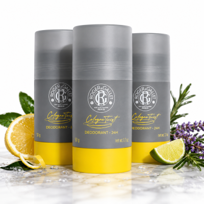 Three Roger & Gallet Cologne Twist Deodorant Sticks (unisex, 50g) are displayed with lemon slices, green leaves, lavender sprigs, and water droplets in the background.