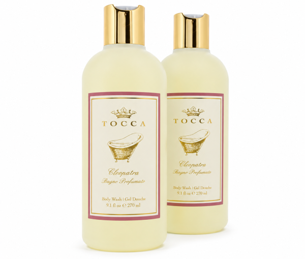 Two bottles of Tocca Cleopatra body wash, each with gold caps, cream-colored liquid, and a label featuring a gold motif and product details.