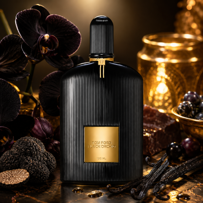 A bottle of Tom Ford Black Orchid Eau de Parfum Spray, Unisex, 100ml rests on a reflective surface surrounded by dark orchids, gold accents, vanilla pods, grapes, and truffles, all illuminated by dramatic lighting.