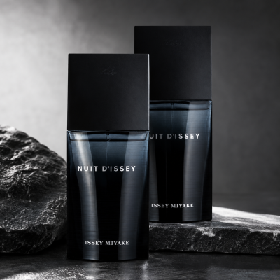Two bottles of 2x Issey Miyake Nuit d’Issey 75ml EDT Eau De Toilette Spray for Men are displayed on a dark stone surface with a gray background.