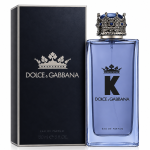 A 150ml spray bottle of Dolce & Gabbana K Eau de Parfum, topped with a distinctive crown-shaped cap, is displayed beside its black box adorned with the brand’s logo and crown motif.