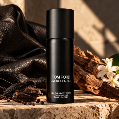2x Tom Ford Ombré Leather Body Spray, Unisex, 150ml bottles are displayed on a stone surface with leather, wood, and white flowers in the background.