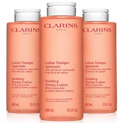 Three identical 400ml bottles of peach-colored Clarins Soothing Toning Face Lotion for very dry or sensitive skin.
